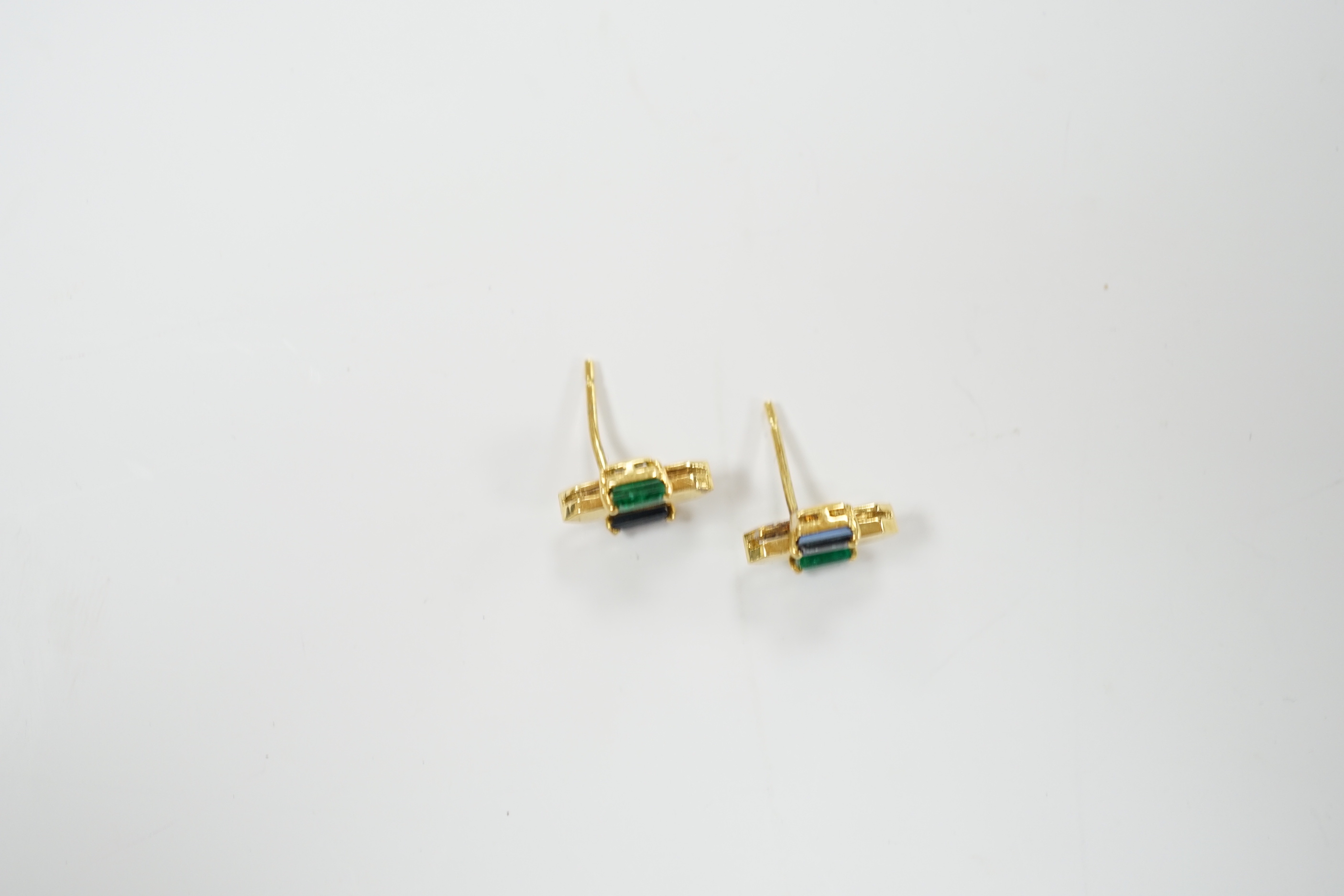A modern pair of 18t gold, two emerald and sapphire set ear studs, 12mm by 7mm, gross weight 3.3 grams.